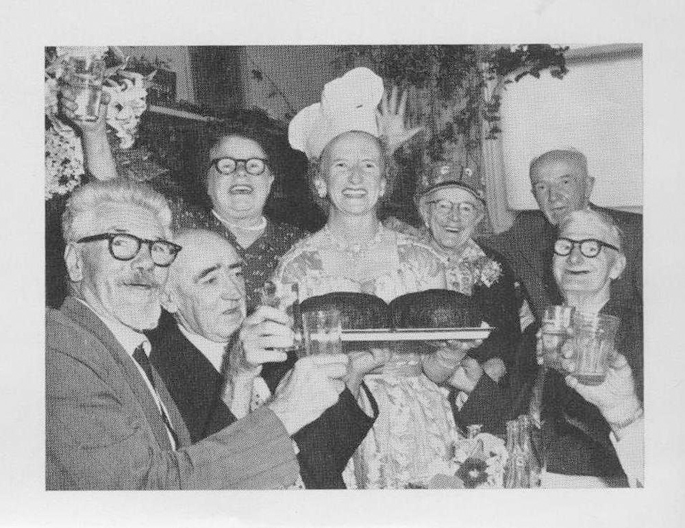 This is an image of Aged Care officer Jess Millot serving Christmas pudding for Coolibah Club members at Christmas time. They are happy and joyful in this black and white photograph.