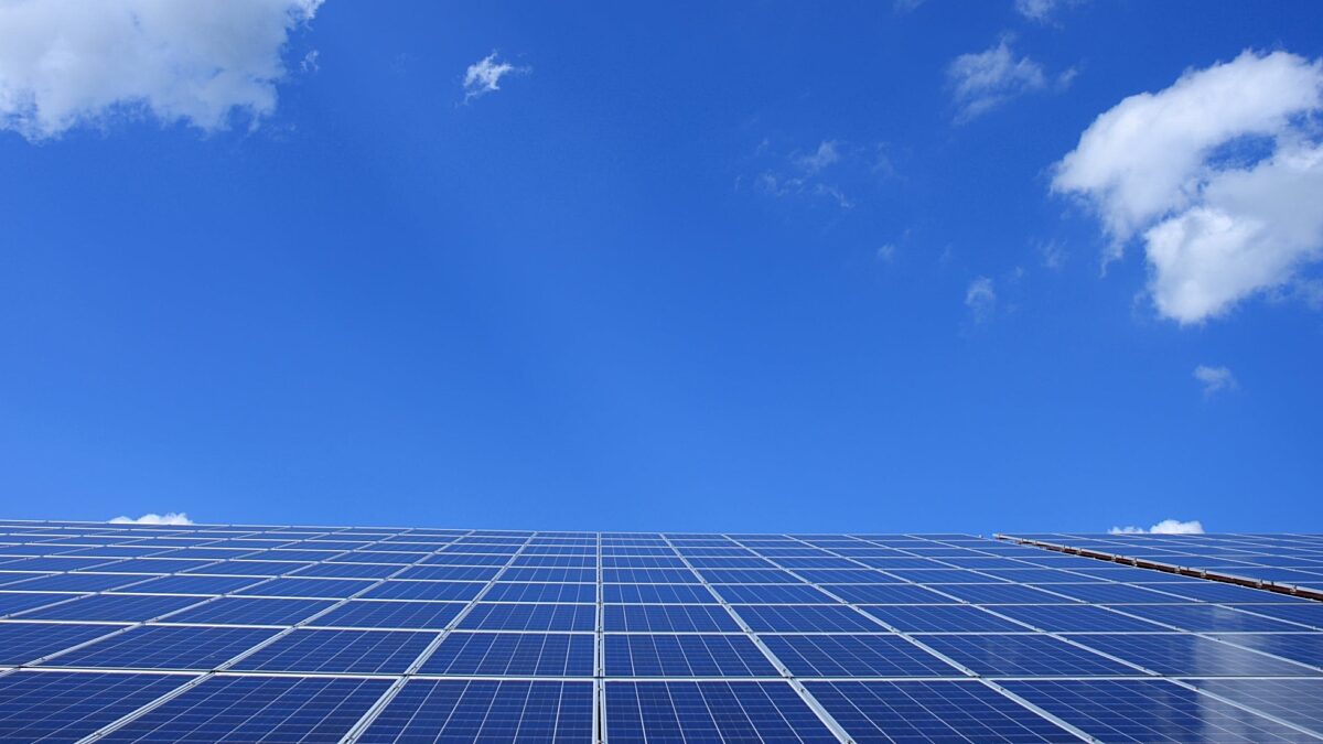 This photo is of solar panels on a roof with a blue sky in the background.