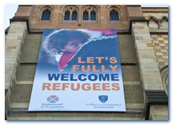 This is photograph of the Lets Fully Welcome Refugees banner that was hung on St Paul's Cathedral. It shows a refugee child and has logos of the Anglican Church and BSL on it.
